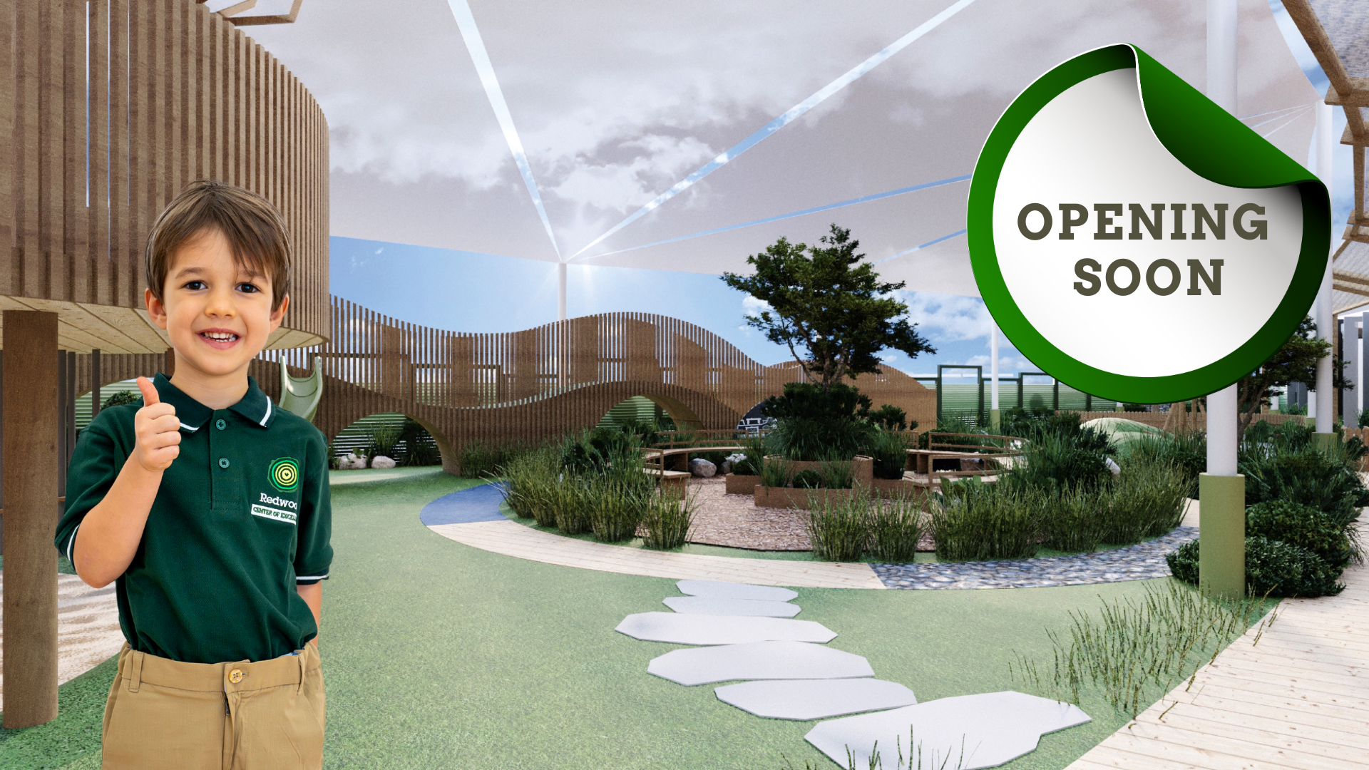 A young boy stands smiling and giving a thumbs up in a landscaped outdoor play area, with a large sign that reads “OPENING SOON” in the background.